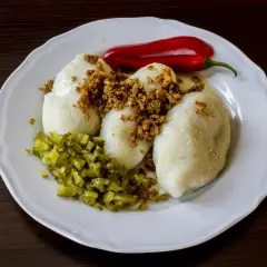 Pyszne kartacze z mięsem, okraszone skwarkami, podane z ogórkiem kiszonym i ostrą papryczką.